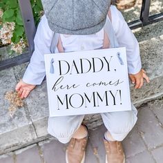 a young child holding a sign that says time to give mommy our last name