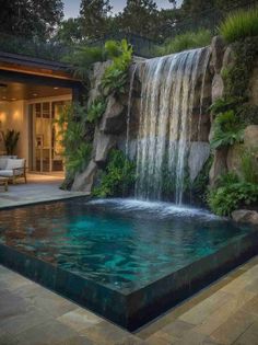 an outdoor pool with waterfall in the middle