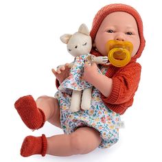 a baby doll with a pacifier in its mouth sitting on the ground next to a stuffed animal