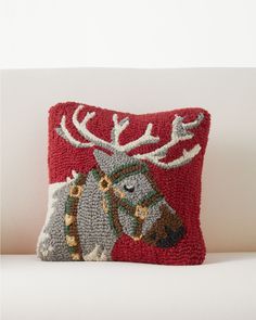 a red pillow with an embroidered moose on it