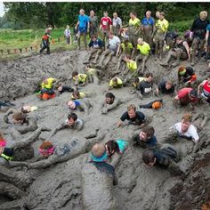 a group of people standing and laying in mud