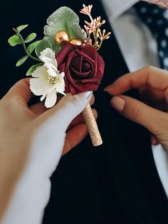 a person holding a boutonniere with flowers on it