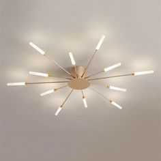 a modern ceiling light with multiple lights on the top and bottom, in an empty room