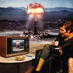 two people sitting in front of a television with an explosion coming out of the screen