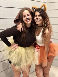 two girls dressed up in costumes posing for the camera with their arms around each other