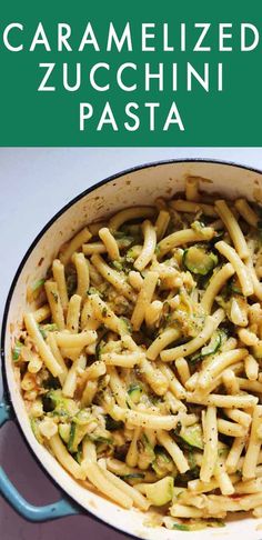 a pan filled with pasta and broccoli on top of a table next to a green sign