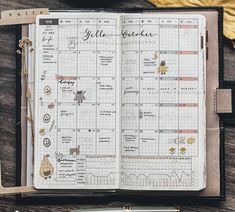 an open planner sitting on top of a wooden table