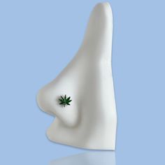 a white ceramic object with a green leaf on it