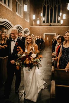 a bride and groom walking down the aisle at their wedding ceremony in an old church