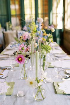 the table is set with flowers and candles