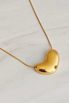 This Bold Molten Heart Necklace is as stylish as it is eye-catching. Featuring an impressive dimensionally rounded heart pendant hung on a round herringbone chain, it is sure to make any outfit stand out. Material Composition: 18k gold plated stainless steel, water and tarnish resistant Lead and Nickel free Imported Trendy Yellow Gold Heart Necklace, Gold Heart Pendant Necklace With Box Chain, Gold Heart Pendant Necklace Trendy, Gold Heart Necklace With Box Chain, Trendy Gold Heart Pendant Necklace, Modern Gold Necklace With Heart Pendant, Modern Gold Heart Pendant Necklace, Modern Yellow Gold Heart Necklace, Modern Heart-shaped Necklace For Valentine's Day