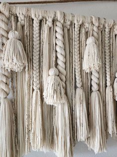 macrame wall hangings with tassels and ropes attached to the wall