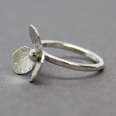 A sweet little flower handmade from sterling silver adorns this beautiful ring.  Hand fabricated from sterling silver sheet, hand sawed, forged, textured, soldered and polished.  It's a labor of love.  Each flower is unique and one of a kind.  Size 8.5 US-This ring can not be resizedSolid 925 Sterling SilverBand width 2mm, lightly hammeredArtisan made in TexasArrives thoughtfully packaged in a signature jewelry boxCheck out all of my handmade rings:  https://www.etsy.com/shop/KMBankston?ref=em&a Handmade Sterling Silver Petal Jewelry, Dainty Handmade Silver Flower Ring, Delicate Handmade Silver Flower Ring, Delicate Sterling Silver Flower Ring, Handmade Delicate Silver Flower Ring, Handmade Delicate Flower Ring In Sterling Silver, Handmade White Gold Sterling Silver Flower Ring, Handmade White Gold Flower Ring In Sterling Silver, Minimalist Sterling Silver Flower Ring