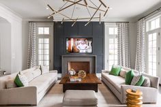 a living room with two couches, a coffee table and a television mounted on the wall