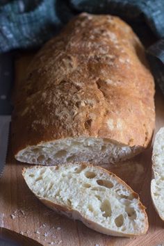 a loaf of bread sitting on top of a wooden cutting board next to a knife