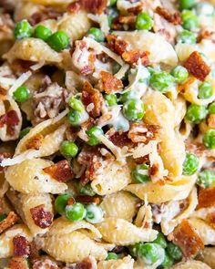 pasta with peas and bacon in a white bowl