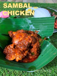 some food is sitting on top of a leafy green plate with the words sambal chicken