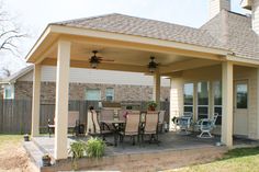 a covered patio with table and chairs on it