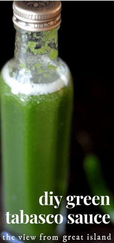 a bottle filled with green tacos sauce sitting on top of a table next to a plate