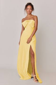 a woman in a yellow dress posing for the camera