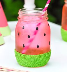 a mason jar filled with watermelon drink sitting on top of a table