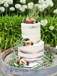 a three tiered cake with figs and berries on top