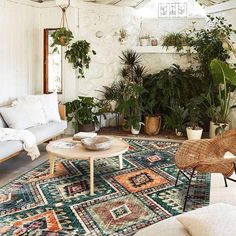 a living room filled with lots of plants and furniture