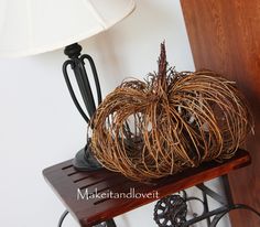 a decorative pumpkin sitting on top of a wooden shelf next to a lamp and mirror