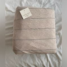 a pillow with a tag on it sitting on a bed