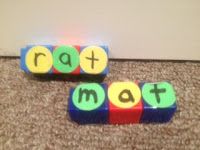 two toy blocks that spell out the word ratt mat next to each other on carpet