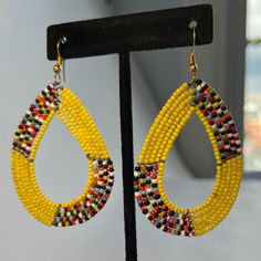 These beautiful earrings are made from beads inspired by the Masai tribe of Kenya. Each earring is handmade Message me to choose your favorite earrings Same price for each Unique Teardrop-shaped Jewelry With Colorful Beads, Unique Teardrop Jewelry With Colorful Beads, Yellow Hoop Earrings For Pierced Ears, Unique Beaded Dangle Hoop Earrings, Unique Yellow Teardrop Jewelry, Yellow Teardrop Beaded Earrings With Colorful Beads, Yellow Round Beaded Earrings, Single Yellow Small Hoop Earring, Yellow Dangle Hoop Earrings With Ear Wire