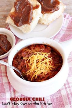 two white bowls filled with chili and bread