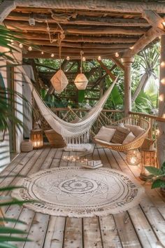 a hammock hanging from the ceiling on a porch with lights strung around it