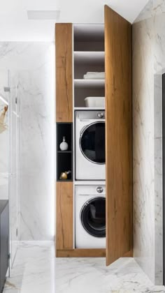 a washer and dryer in a bathroom with marble walls