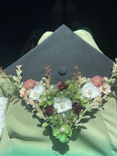 a graduation cap with flowers and greenery on it