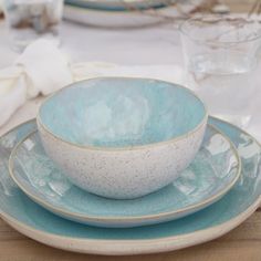 a blue and white bowl sitting on top of two plates