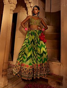 Make a style statement like a traditional diva in this alluring lehenga set featuring a geometrical print skirt with a multi-colour embroidered border and an intricately embroidered blouse styled with a coordinated dupatta. Colourful Blouse, Geometrical Prints, Cancan Lehenga, Lehenga And Blouse, Green Dupatta, Printed Lehenga, Colorful Blouses, Green Lehenga, Green Chevron