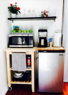 a small kitchen with stainless steel appliances and wood flooring