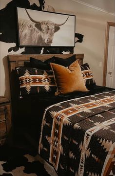 a bed with black and brown bedspread in a bedroom next to a cow head