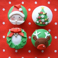 four decorated cupcakes with santa claus and reindeer faces