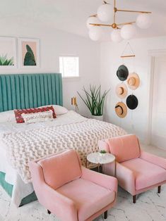 a bedroom with two chairs and a bed in the middle, one has pink upholstered bedspread