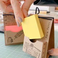 someone is making a small box out of paper and glues it into the shape of a house