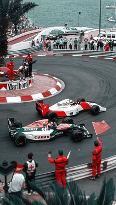 two racing cars on a race track with people watching