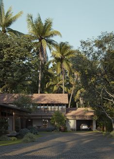 a house in the middle of some palm trees and dirt road with a car parked on the driveway