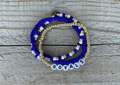 These Royals bracelets are the perfect way to show your team pride for the big game! Pair them with any outfit. This listing is for 3 bracelets as shown in pictures.  TO ORDER:  1. Pick bracelet length  2. Pick letter color 3. Submit and I'll get to work :)  PRODUCT DETAILS:  - Bracelets are made with sturdy jewelry elastic - Listing is for three bracelets  - All orders are final. Please double check your bracelet size  CARING TIPS:  - Do not expose jewelry to water  - Treat and store jewelry gently  - Roll bracelets on rather than stretching band to get on  Don't see your teams bracelets on our shop? Or have a custom team bracelet you want? Head to this link to order your custom ones!  https://kanaeohana.etsy.com/listing/1591607617/custom-sports-team-bracelets-team  We are HAPPY to do bul Fan Bracelet, It Band Stretches, Team Bracelets, Baseball Bracelet, Royals Baseball, Sports Bracelet, Store Jewelry, Letter Beads, Big Game