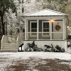 a small white house in the snow with stairs leading up to it's porch