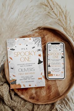 a wooden plate with a book and an iphone on it next to a white blanket