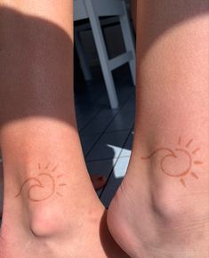 two people with sun and moon tattoos on their legs