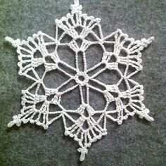 a crocheted snowflake is laying on the ground