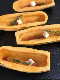 four pieces of buttered squash with herbs on them